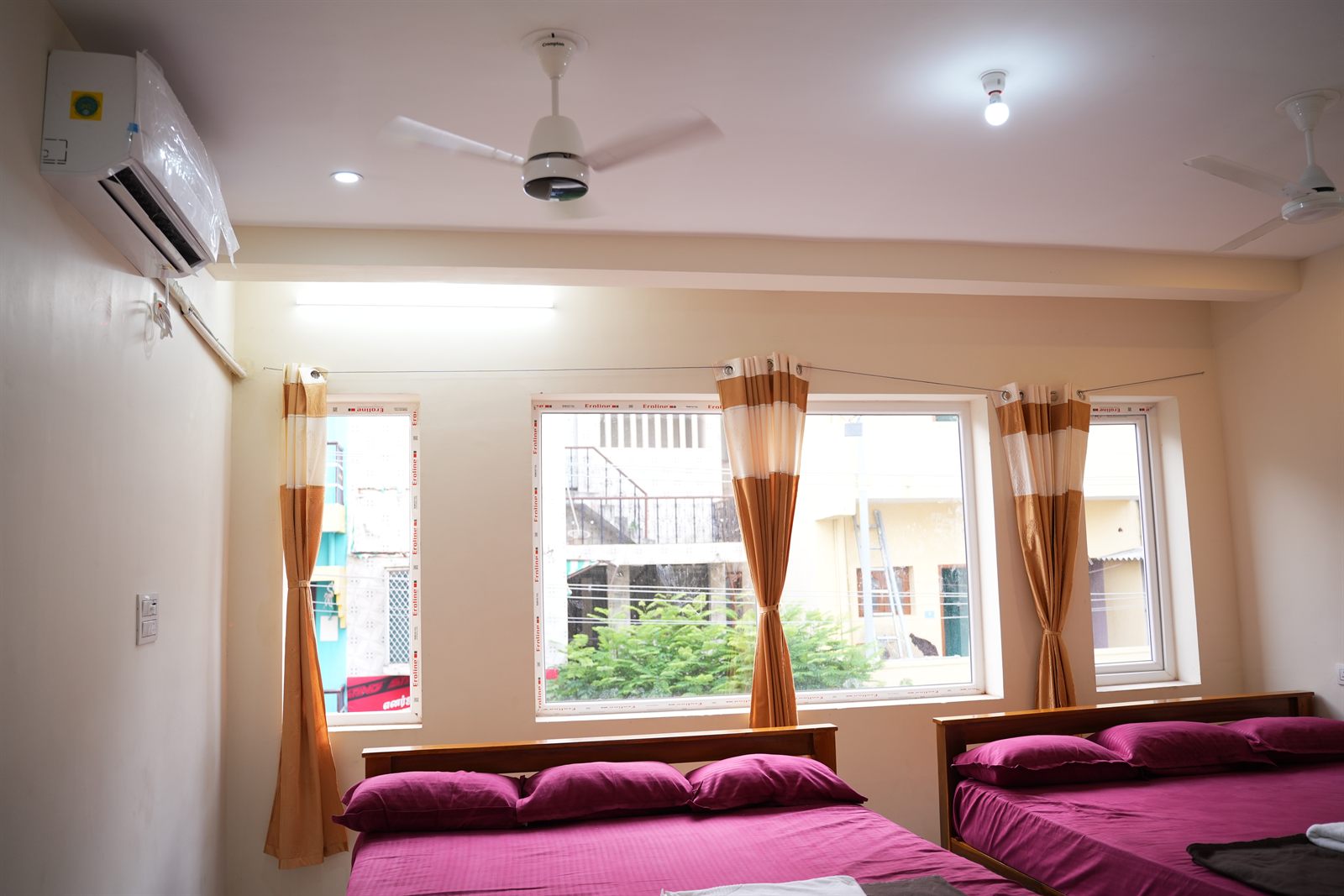 Bright family room with three windows and orange curtains