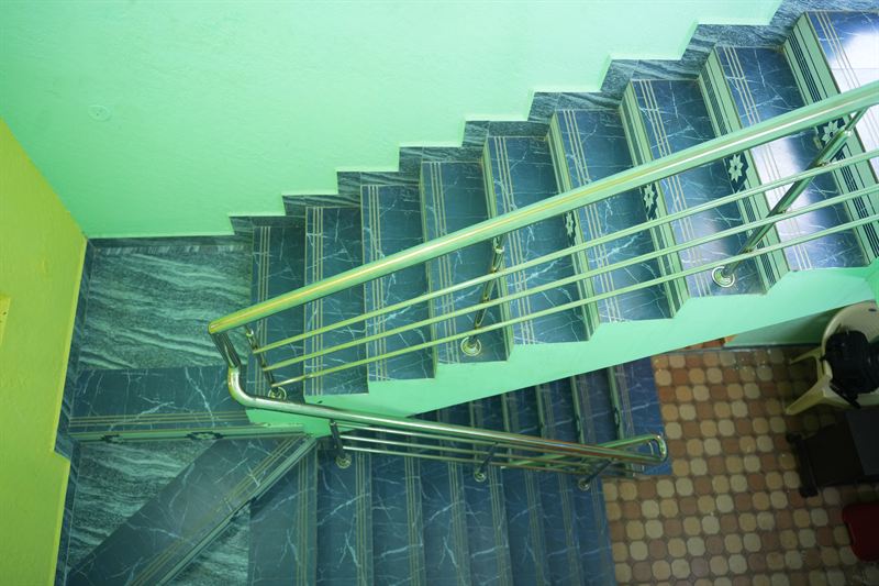 Marble staircase with gold inlay patterns and a chrome railing