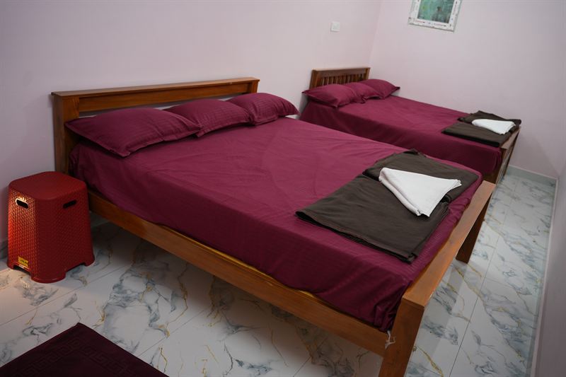 Standard room with a double and single bed and towels laid out